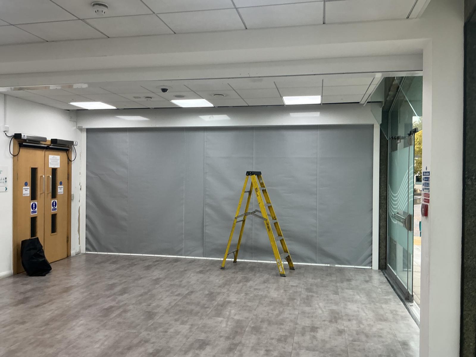 Fire curtain deployed across an opening, viewed from the side