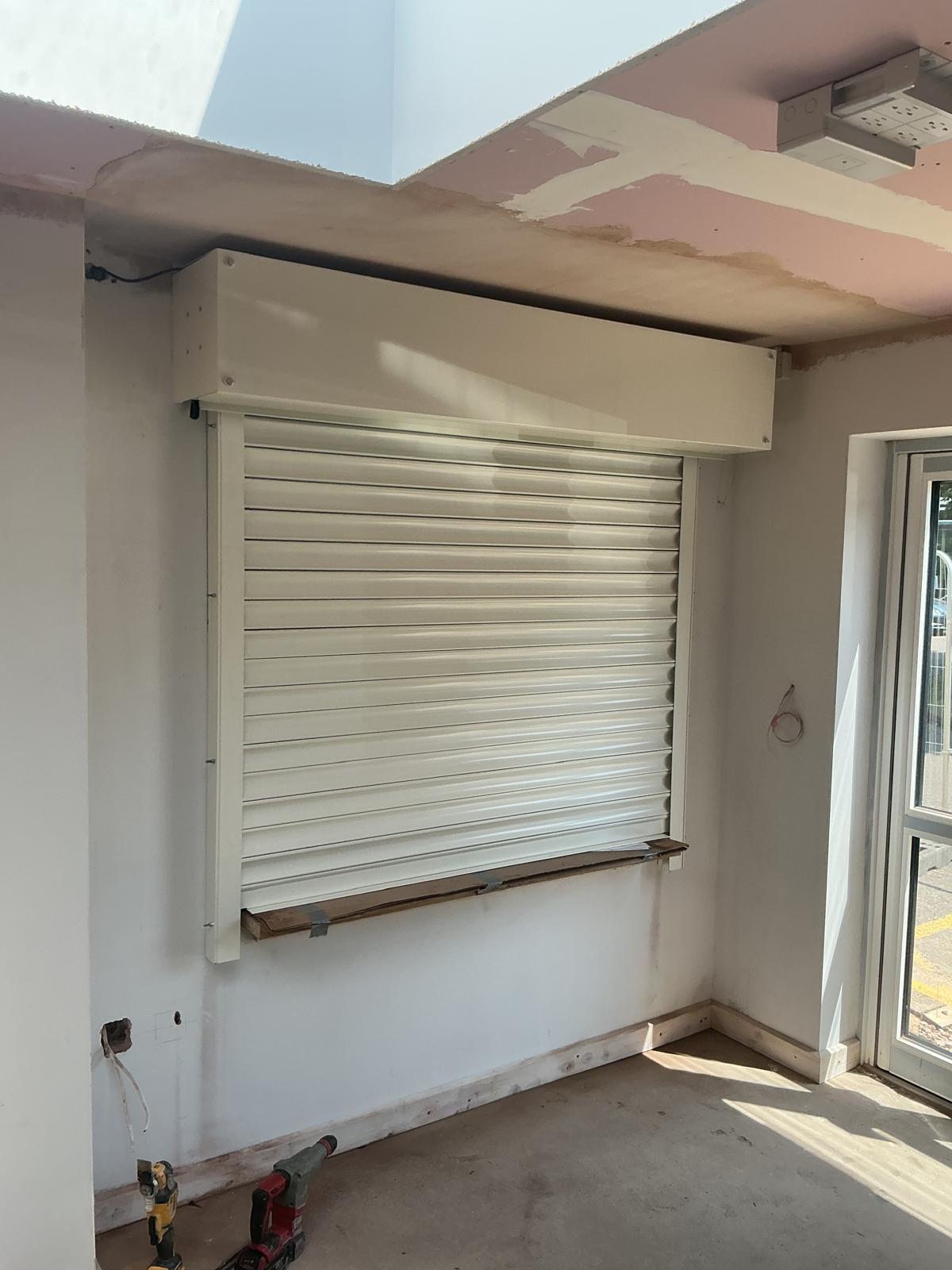 Roller shutter part open with a safety barrier in place during works